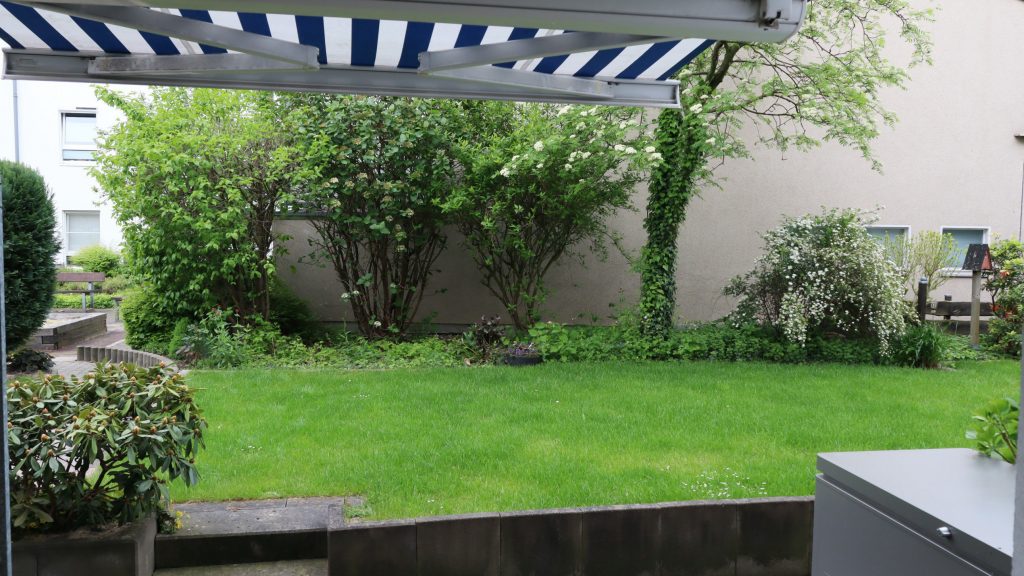 Blick von der Terrasse mit Markise in den Garten